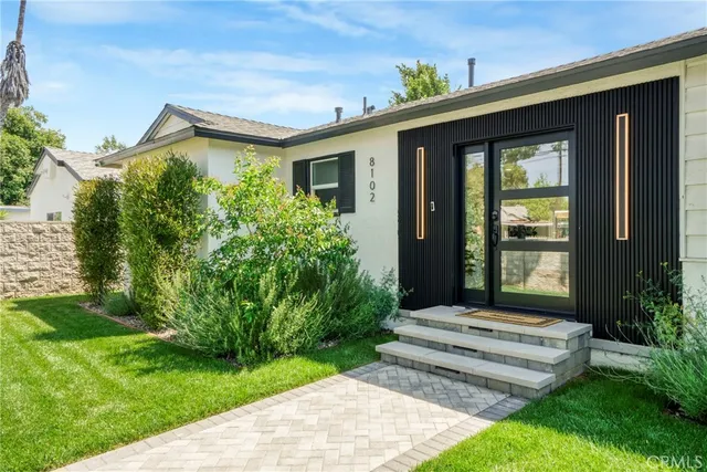 a front view of a house with a tree