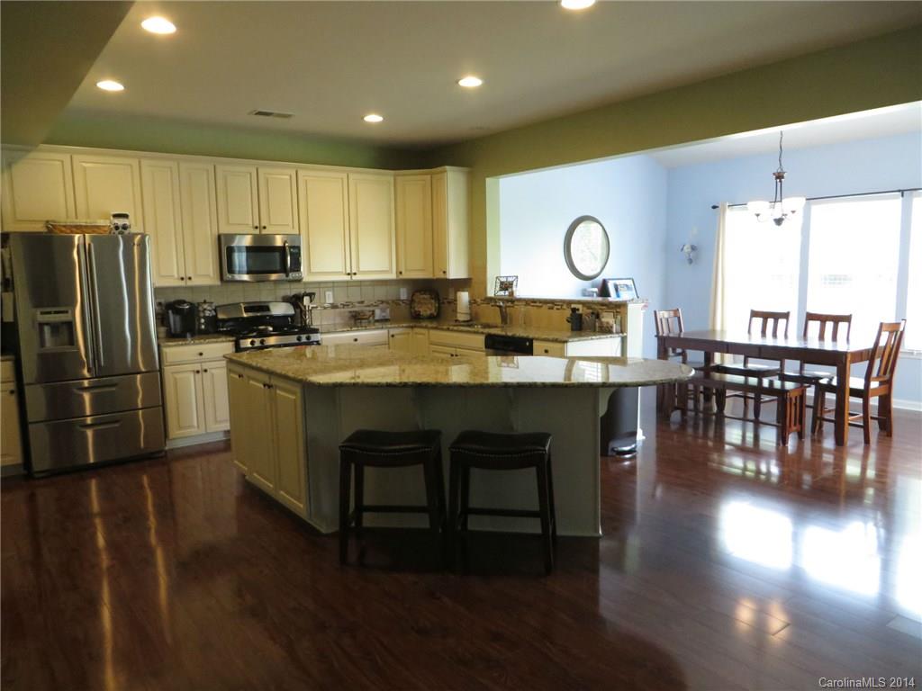 3005 Fallondale Road Waxhaw, NC 28173 - Photo 7 of 20 a kitchen with stainless steel appliances granite countertop a stove a refrigerator a kitchen island a dining table and chairs