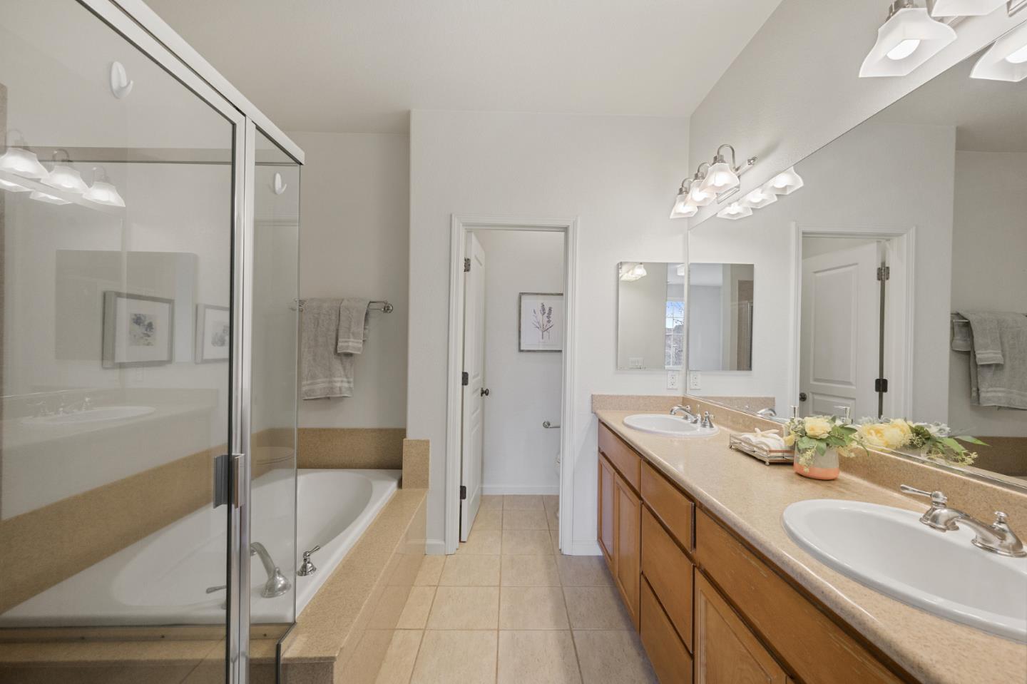 4517 Lick Mill Boulevard Santa Clara, CA 95054 - Photo 33 of 38 a spacious bathroom with a granite countertop sink a mirror a bathtub and shower