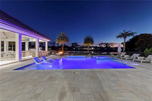 a view of swimming pool with red chairs