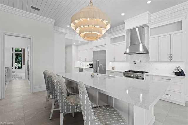 a kitchen with stainless steel appliances a table chairs and a chandelier