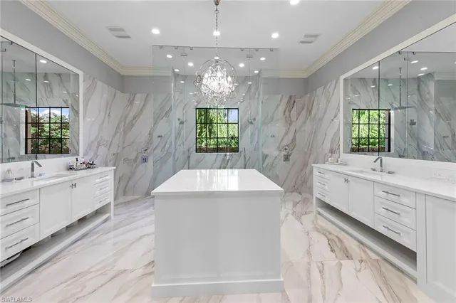 a large white kitchen with a large window a sink stainless steel appliances and cabinets