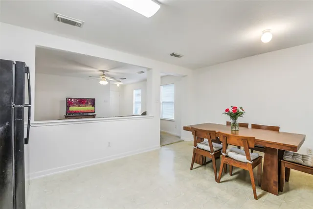 a living room with furniture and a dining table with wooden floor