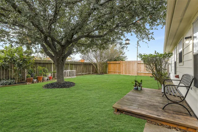 a view of a backyard with table and chairs and a tree