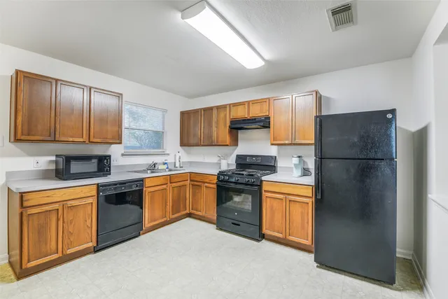 a kitchen with stainless steel appliances granite countertop a refrigerator stove a sink dishwasher and microwave