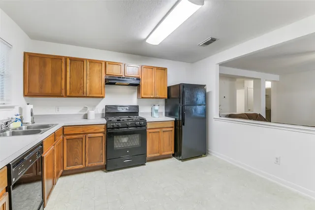 a kitchen with stainless steel appliances granite countertop a stove a sink dishwasher and a refrigerator