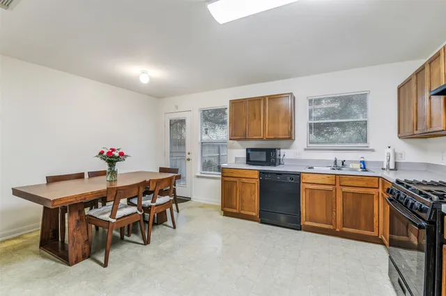 a kitchen with granite countertop a table chairs stove and cabinets