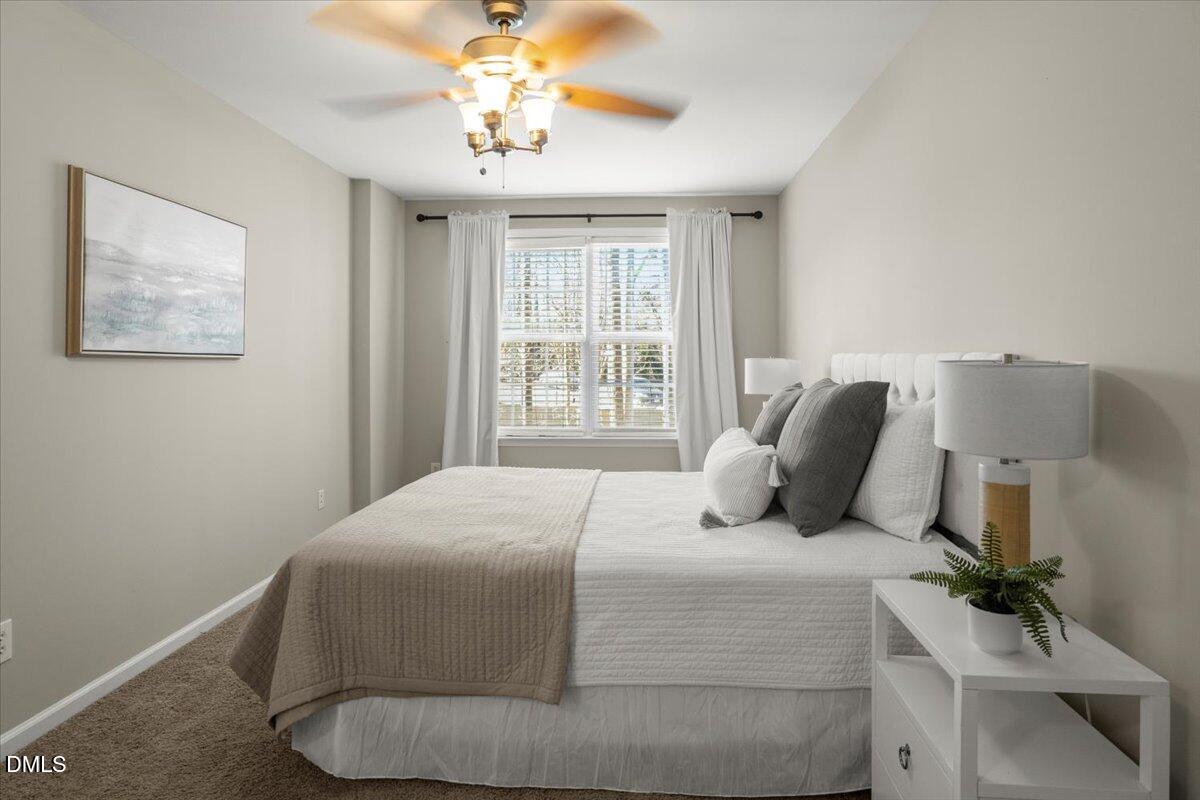 2920 Barrymore Street, Unit 106 Raleigh, NC 27603 - Photo 14 of 31 a bedroom with a bed and a chandelier