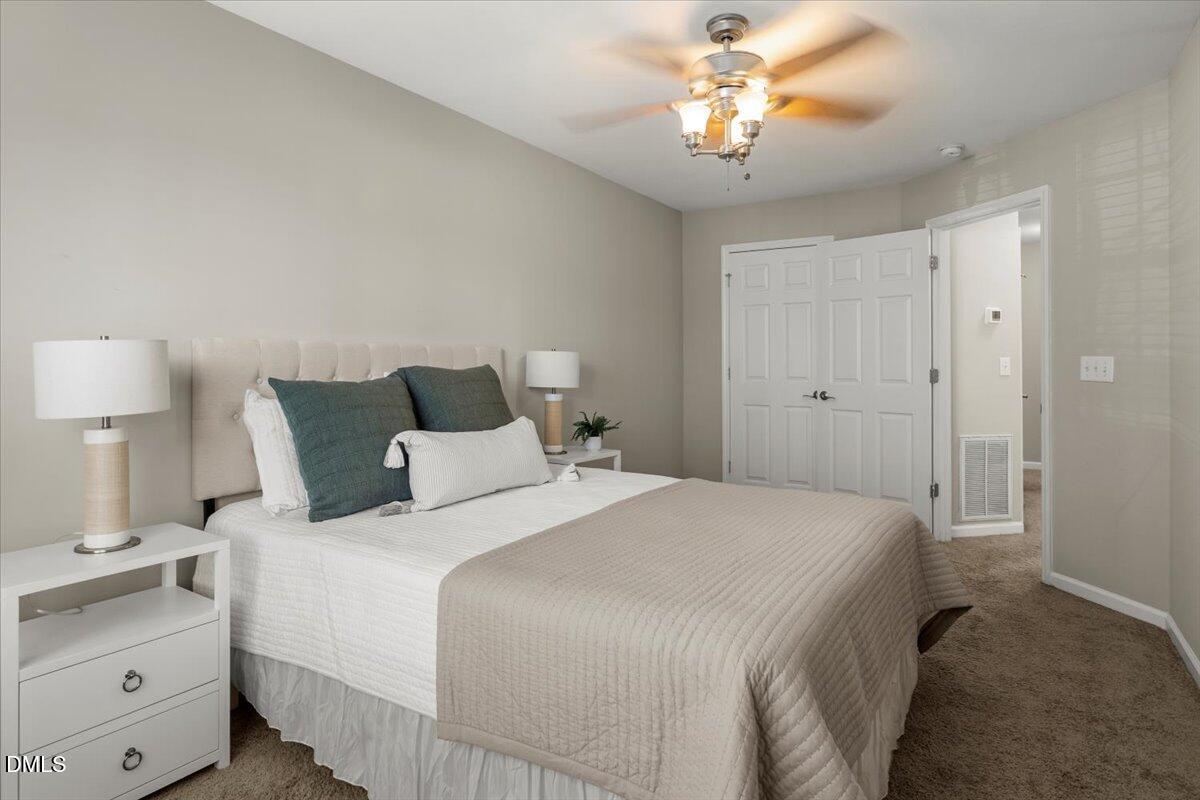 2920 Barrymore Street, Unit 106 Raleigh, NC 27603 - Photo 15 of 31 a bedroom with a bed and a chandelier