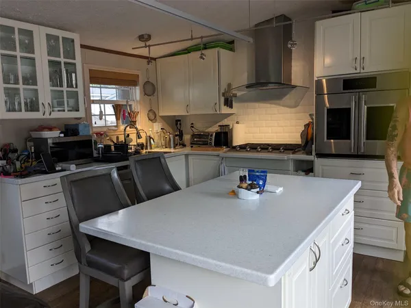 a kitchen with kitchen island a stove a refrigerator and a dining table with wooden floor