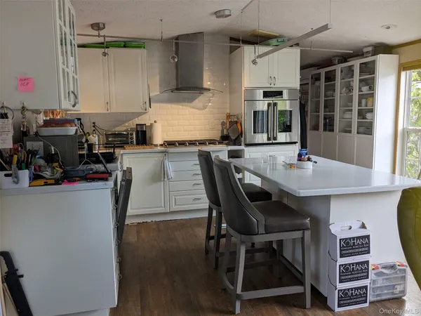 a kitchen with kitchen island a dining table chairs and a wooden floor