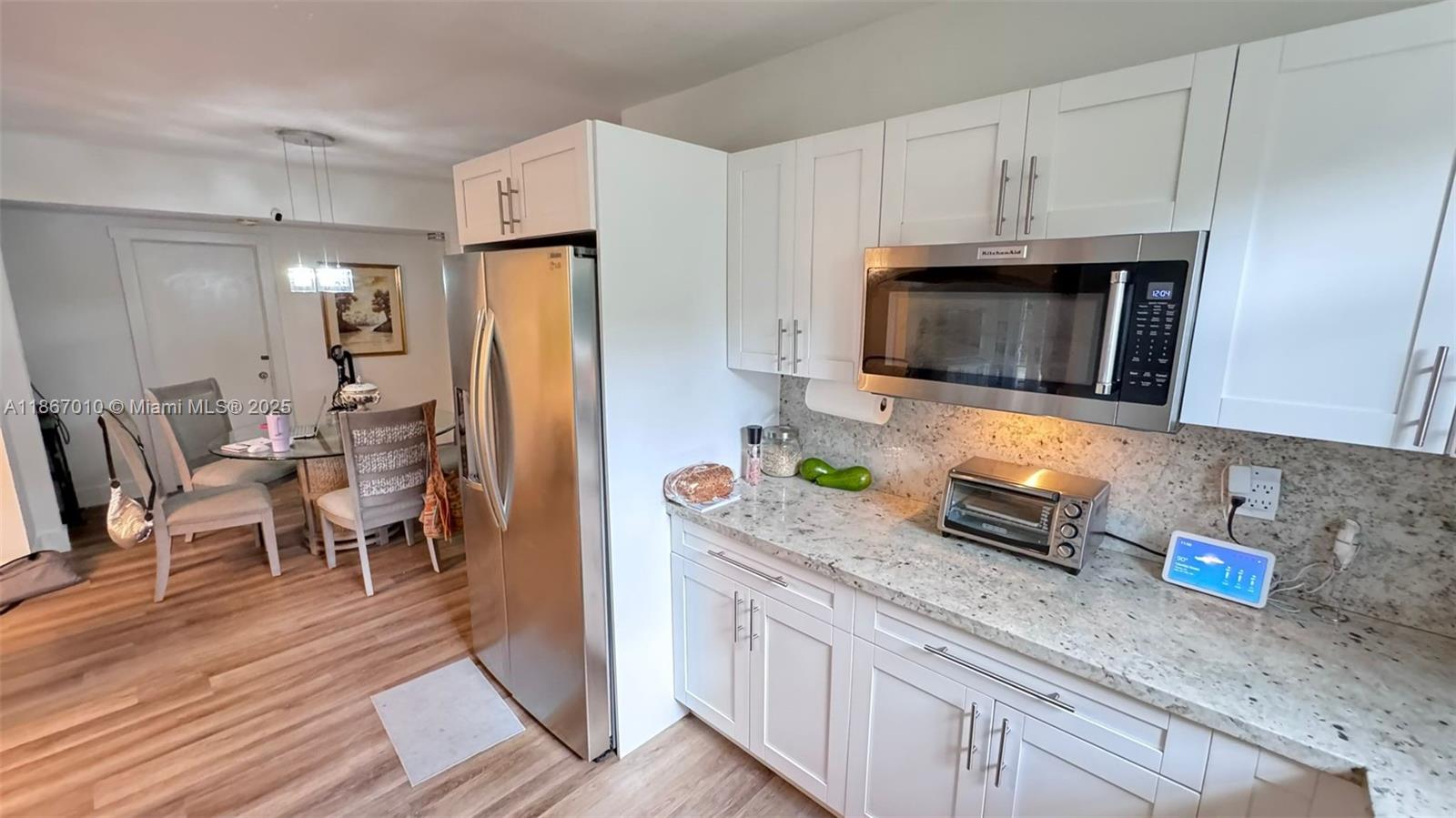 3911 Southwest 61st Avenue Miami, FL 33155 - Photo 23 of 38 a kitchen with stainless steel appliances granite countertop a refrigerator microwave stove and wooden floor