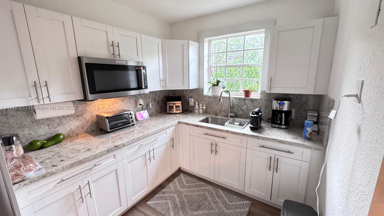 3911 Southwest 61st Avenue Miami, FL 33155 - Photo 24 of 38 a kitchen with appliances a sink a window and cabinets