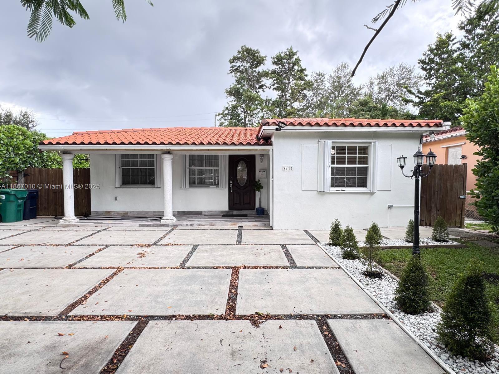 3911 Southwest 61st Avenue Miami, FL 33155 - Photo 4 of 38 a front view of a house with a garden and plants