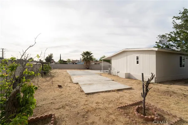 a view of a dry yard with wooden fence