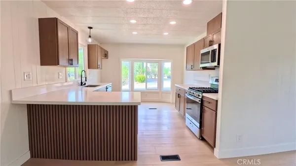 a kitchen with stainless steel appliances a sink stove and cabinets