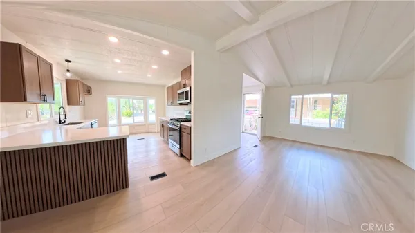 a view of a kitchen with wooden floor and a window
