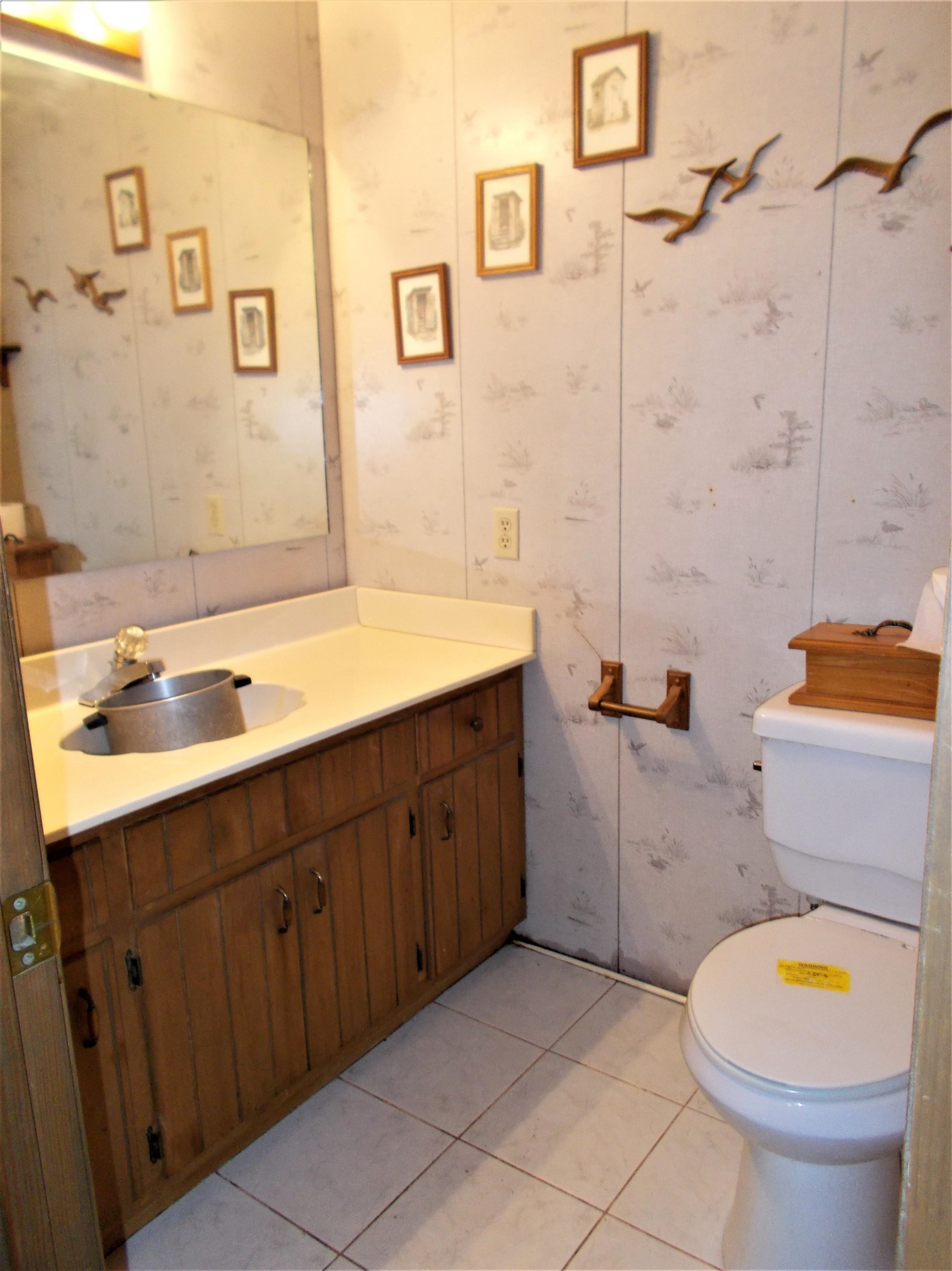 1058 Thumb Road Henning, TN 38041 - Photo 17 of 25 a bathroom with a granite countertop toilet sink and mirror