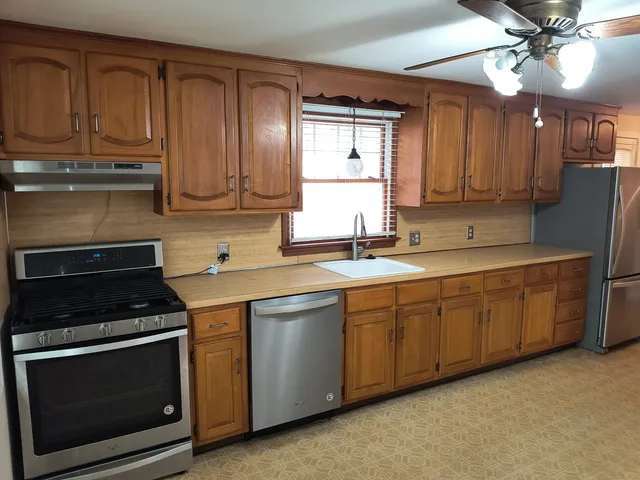 a kitchen with stainless steel appliances granite countertop a stove a sink and a microwave