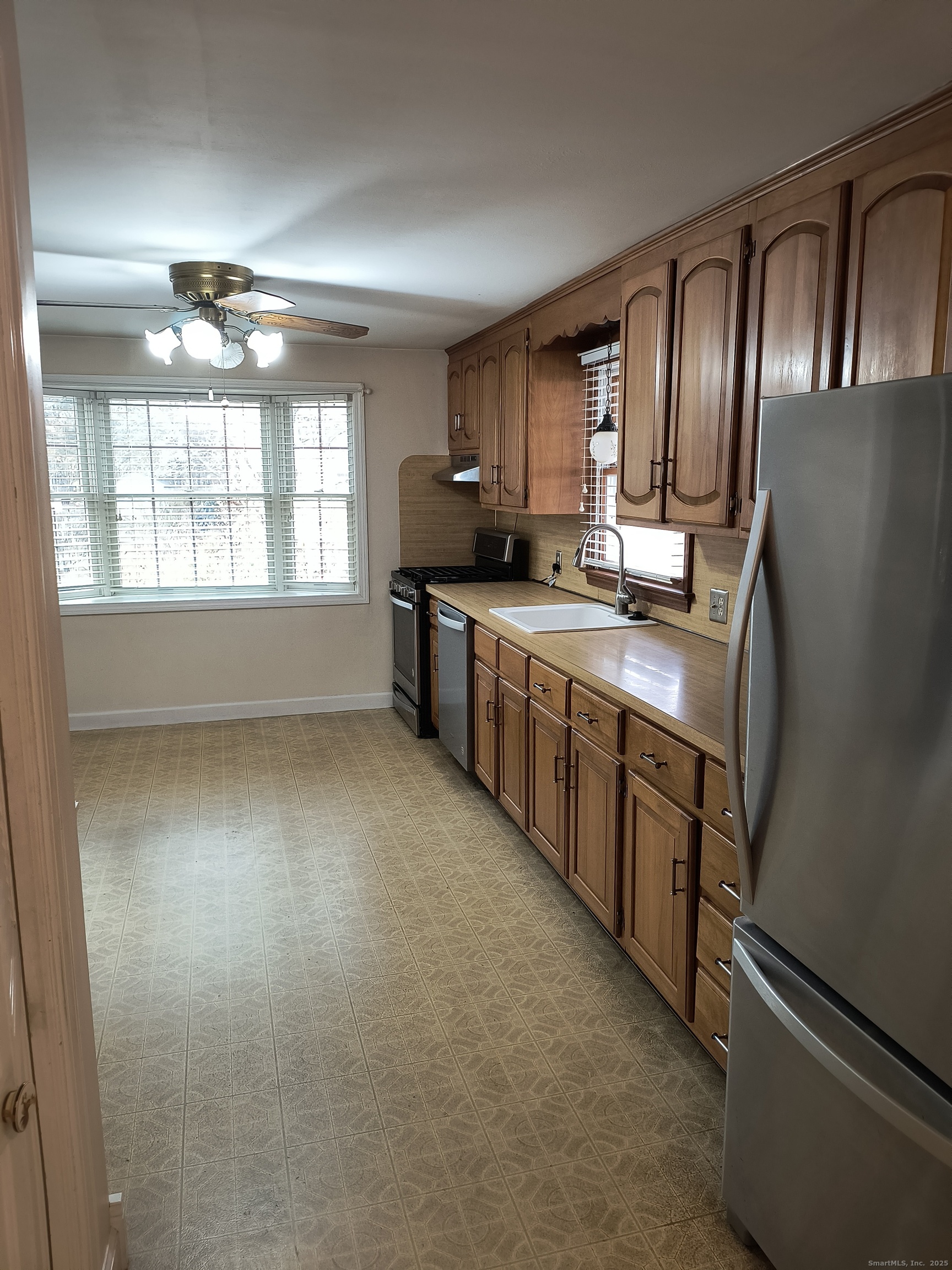 28 McLaughlin Terrace Derby, CT 06418 - Photo 33 of 37 a large kitchen with stainless steel appliances granite countertop a refrigerator a sink dishwasher a stove a dining table and chairs with wooden floor
