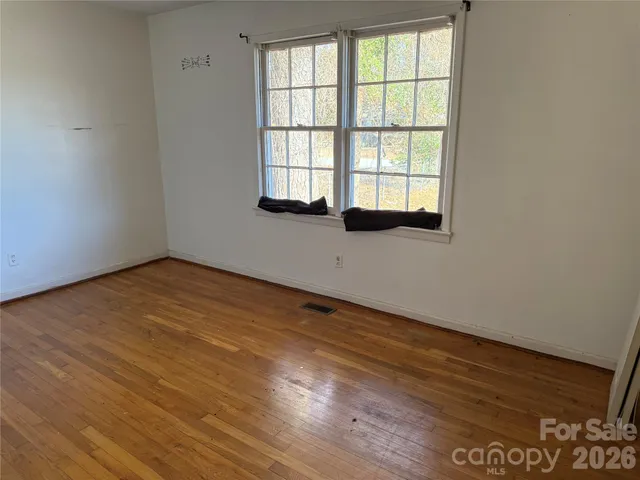a view of an empty room with closet and a window
