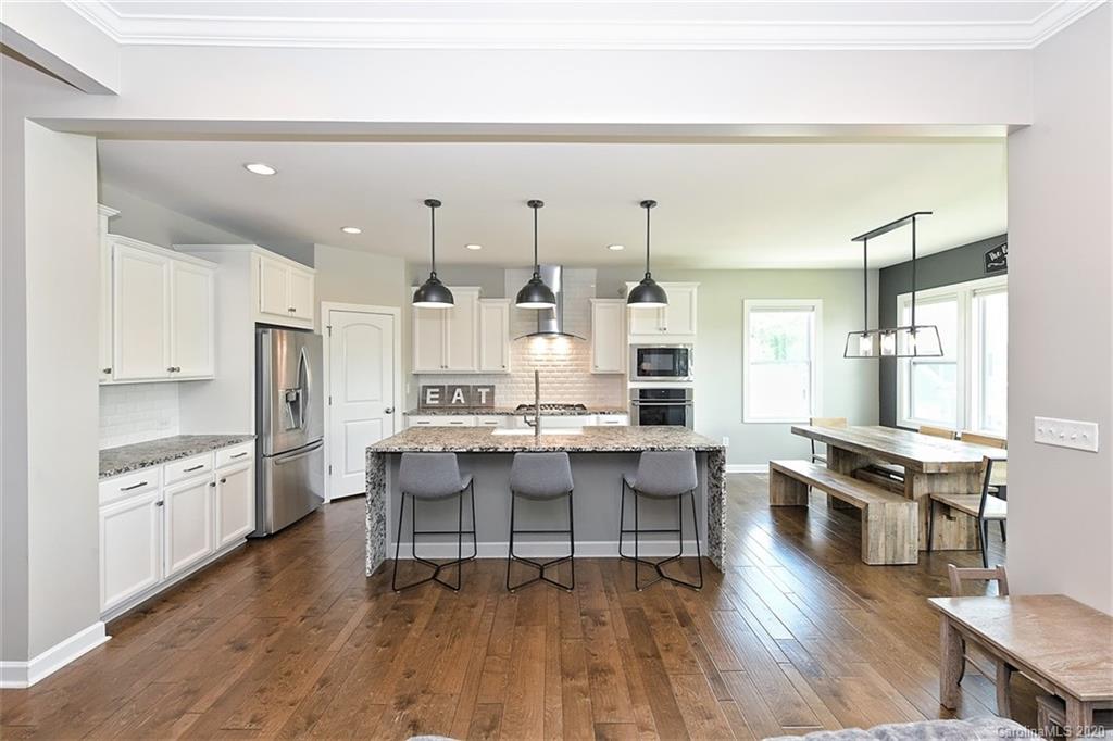 5321 Meadowcroft Way Fort Mill, SC 29708 - Photo 11 of 36 a kitchen with stainless steel appliances a stove a sink dishwasher a refrigerator white cabinets and wooden floor