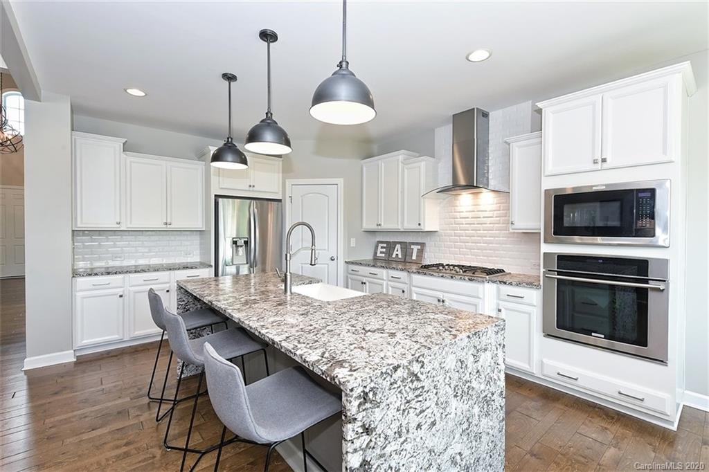 5321 Meadowcroft Way Fort Mill, SC 29708 - Photo 12 of 36 a kitchen with kitchen island granite countertop a stove a sink a center island and wooden floor