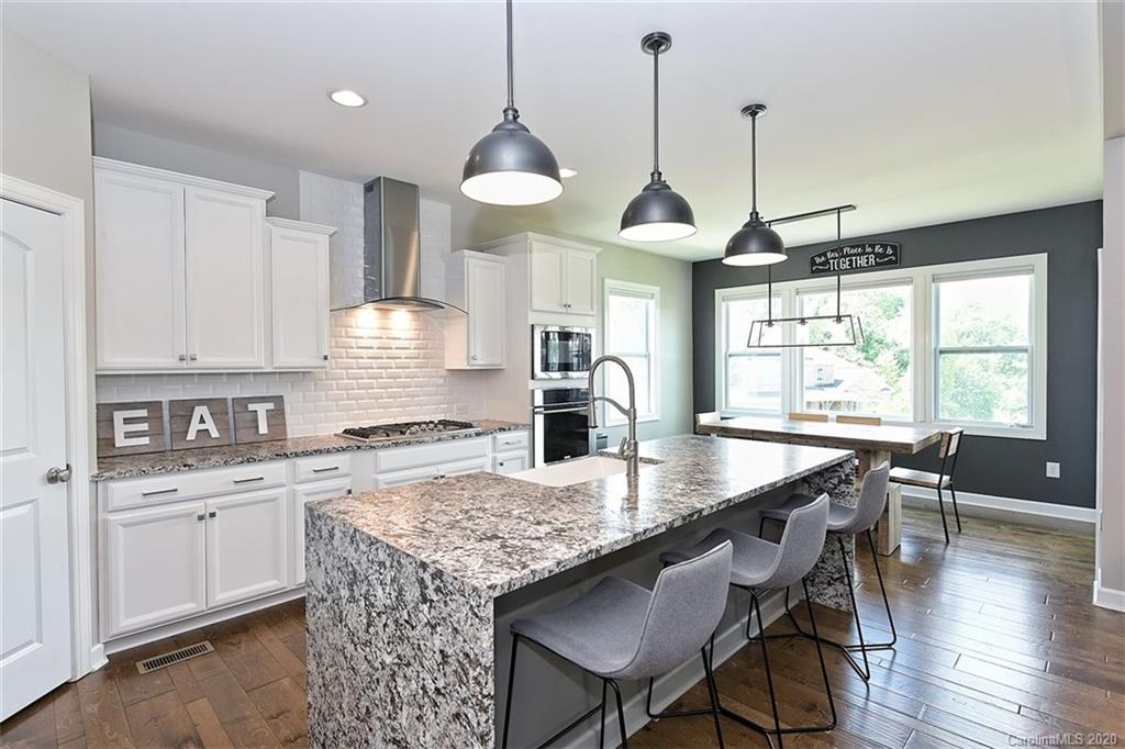 5321 Meadowcroft Way Fort Mill, SC 29708 - Photo 13 of 36 a kitchen with stainless steel appliances granite countertop a stove a kitchen island a table and chairs in it