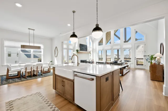 a kitchen with stainless steel appliances kitchen island granite countertop a sink a stove and a wooden floors