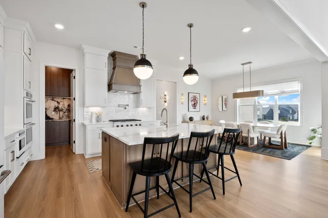 a view of a dining room and livingroom with furniture wooden floor a chandelier