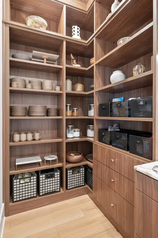 a room with walk in closet and wooden shelves