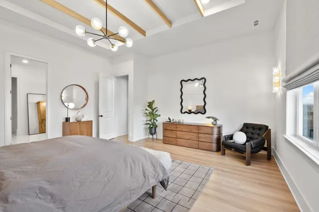 a bedroom with a bed and dresser with mirror