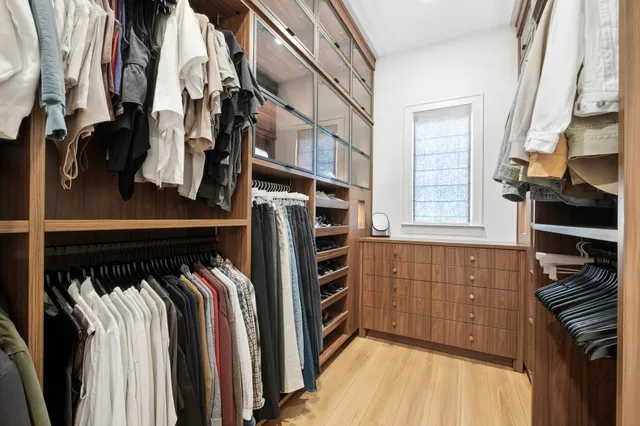 a view of walk in closet with clothes and shoes