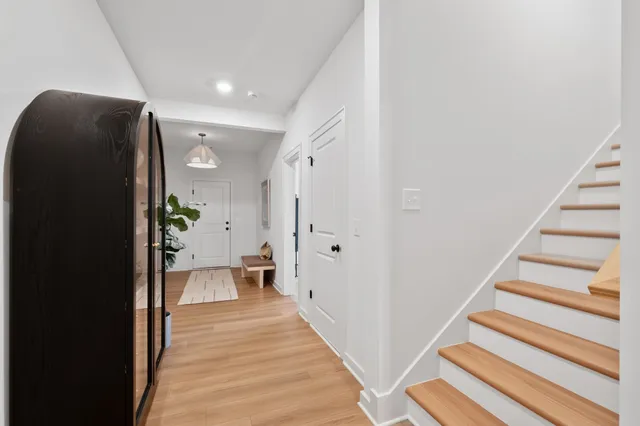 a view of a hallway with wooden floor and staircase