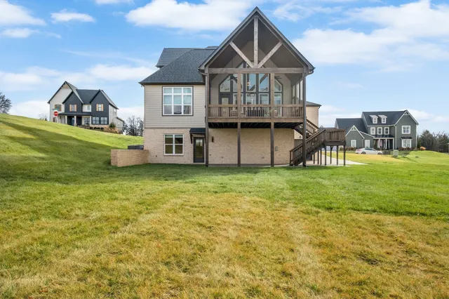 a view of a house with a big yard and large trees