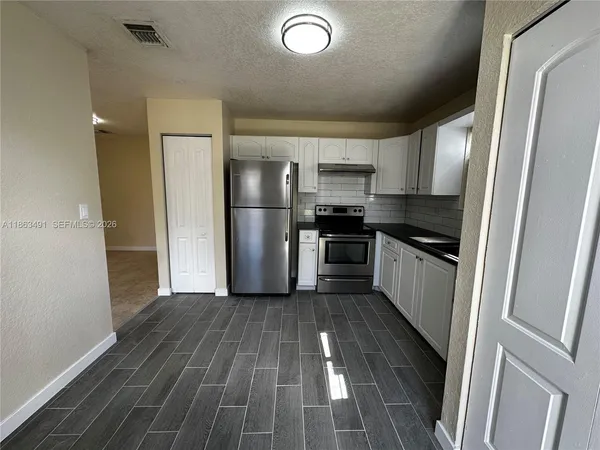 a kitchen with wooden floors and appliances