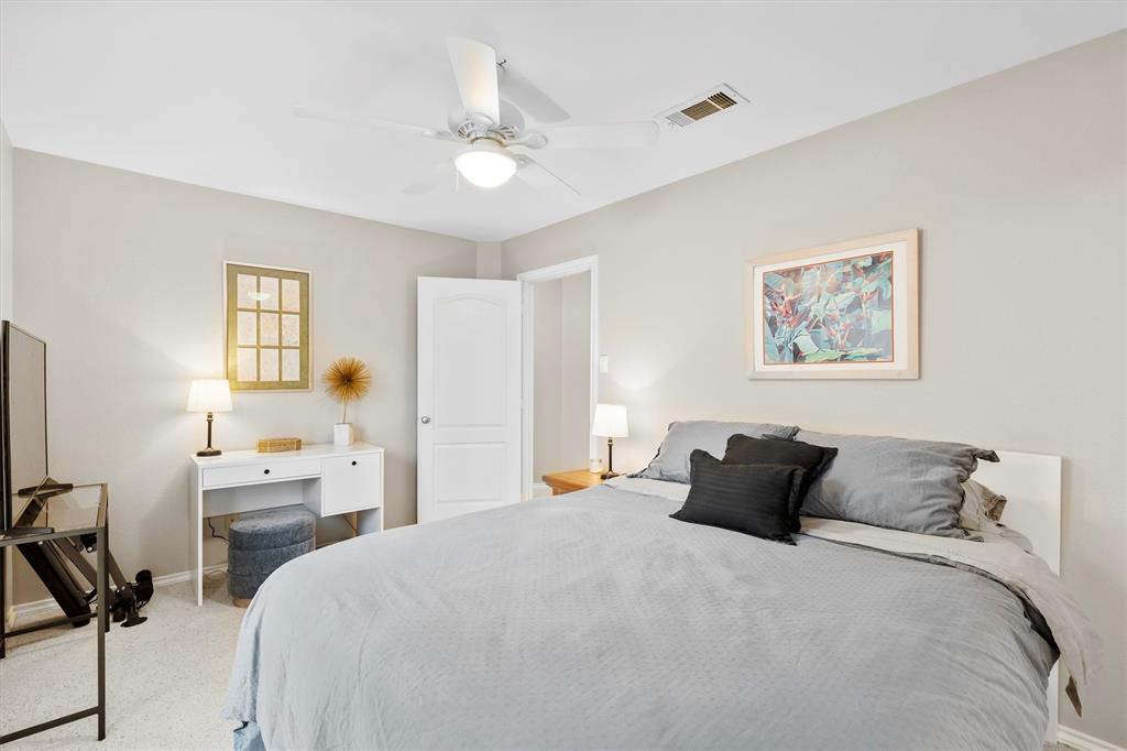 4008 Sherry Lane Addison, TX 75001 - Photo 20 of 39 a bedroom with a bed and a chandelier