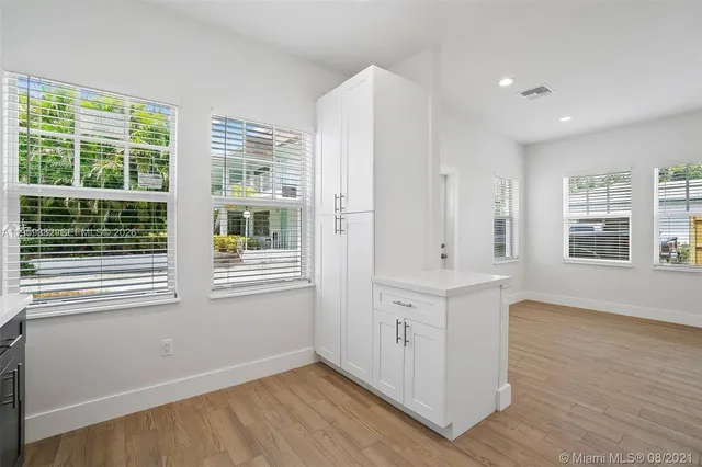a view of empty room with wooden floor and windows