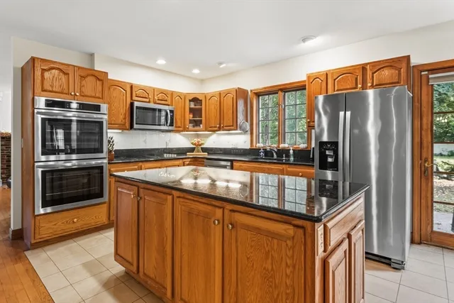 a kitchen with stainless steel appliances granite countertop a refrigerator and a sink