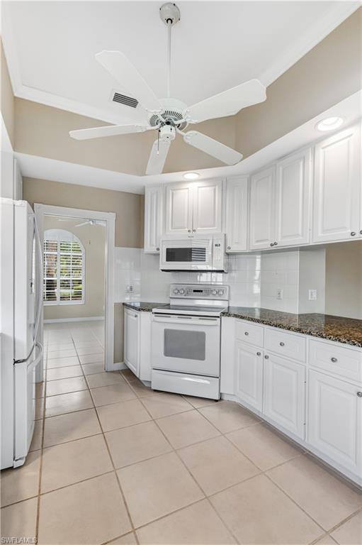 3888 Valentia Way Naples, FL 34119 - Photo 12 of 48 a kitchen with granite countertop a stove a sink and a refrigerator
