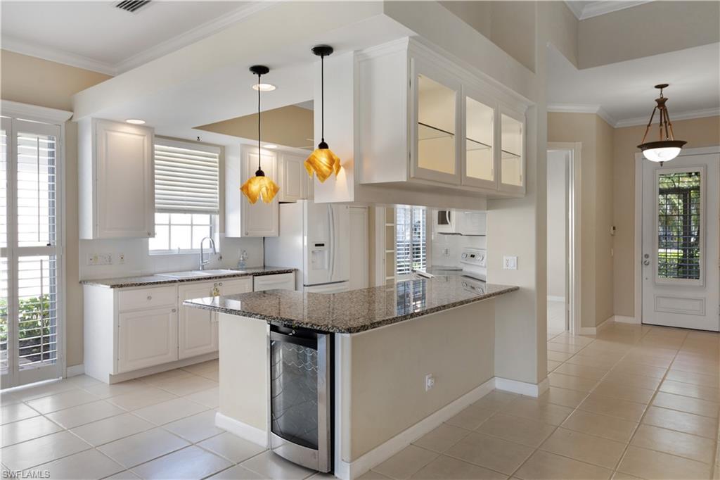 3888 Valentia Way Naples, FL 34119 - Photo 13 of 48 a kitchen with stainless steel appliances granite countertop a sink and a refrigerator