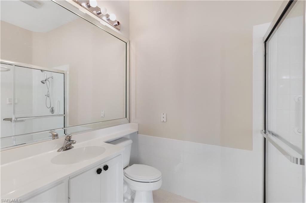 3888 Valentia Way Naples, FL 34119 - Photo 19 of 48 a bathroom with a sink a toilet and a mirror