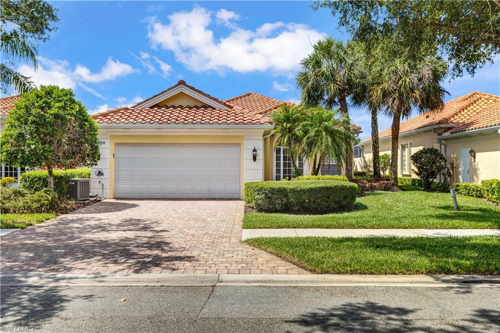 3888 Valentia Way Naples, FL 34119 - Photo 2 of 48 a front view of a house with a yard and garage