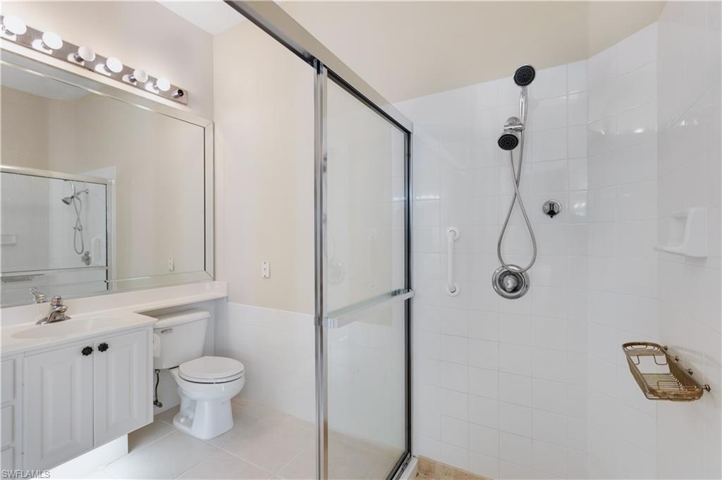 3888 Valentia Way Naples, FL 34119 - Photo 31 of 48 a bathroom with a toilet a sink a mirror and shower
