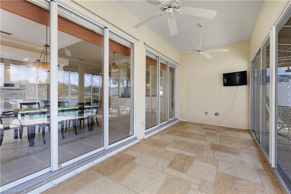 3888 Valentia Way Naples, FL 34119 - Photo 35 of 48 a view of a hall with floor to ceiling windows and dining room