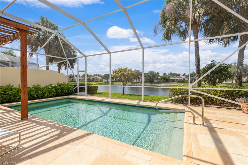 3888 Valentia Way Naples, FL 34119 - Photo 4 of 48 a view of a swimming pool with a yard and palm trees