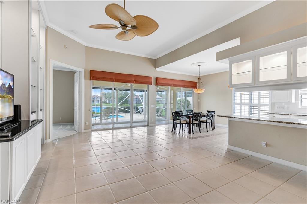 3888 Valentia Way Naples, FL 34119 - Photo 8 of 48 a view of a dining room with furniture a chandelier and a large window