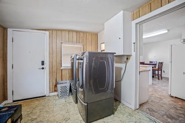 a view of a kitchen with refrigerator and table
