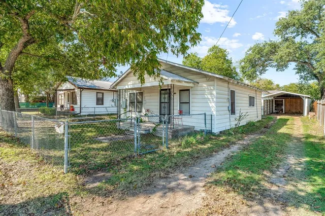 a backyard of a house with table and chairs