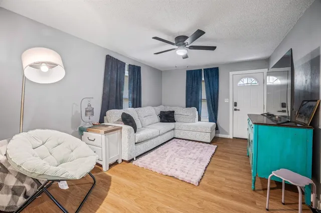 a living room with furniture and a wooden floor